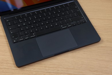 Photo of Leiden, Netherlands - October 6, 2023: Modern black MacBook Air on wooden table, above view