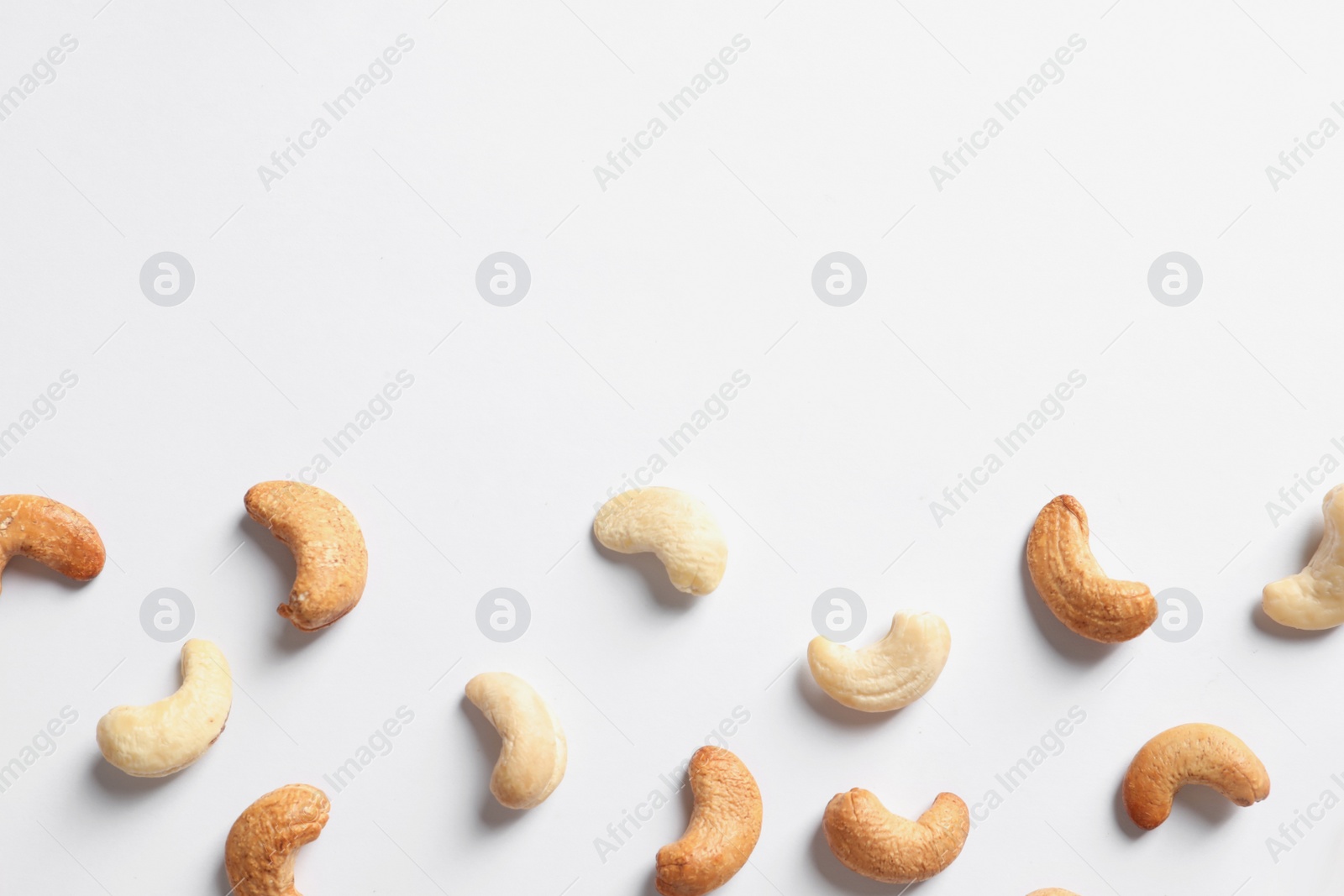Photo of Tasty cashew nuts isolated on white, top view. Space for text