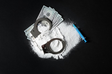 Photo of Composition with heap of cocaine and syringe on black background, top view