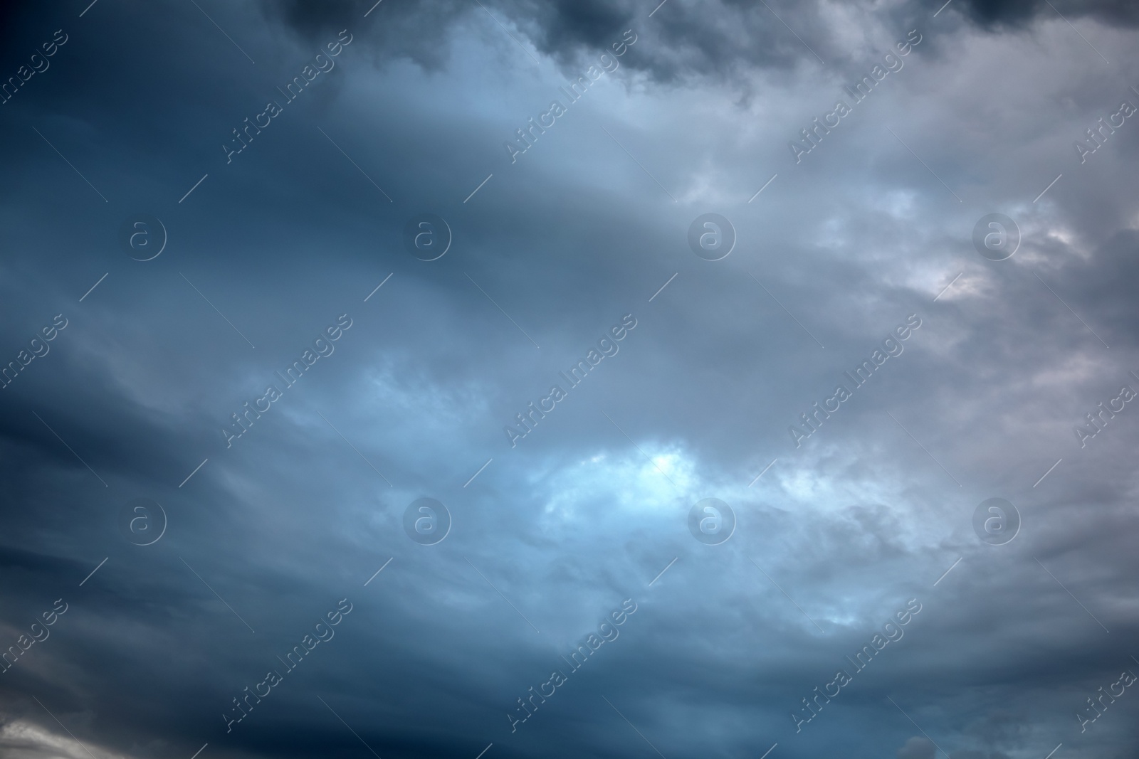 Photo of Picturesque view of bird in sky with heavy rainy clouds