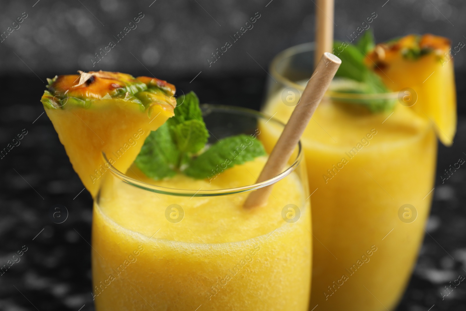 Photo of Tasty pineapple smoothie in glasses on blurred background, closeup