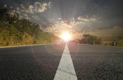 Empty asphalt road at sunrise, closeup view