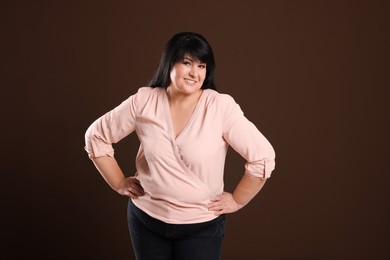 Photo of Beautiful overweight mature woman with charming smile on brown background