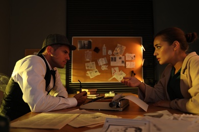 Old fashioned detective working with client in office