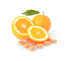 Fresh oranges and blister with cough drops isolated on white