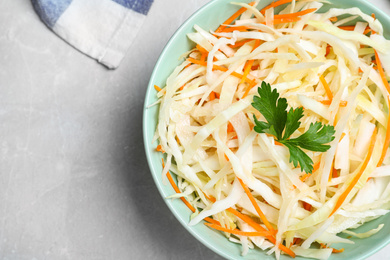 Tasty salad with cabbage and carrot on light grey marble table, top view