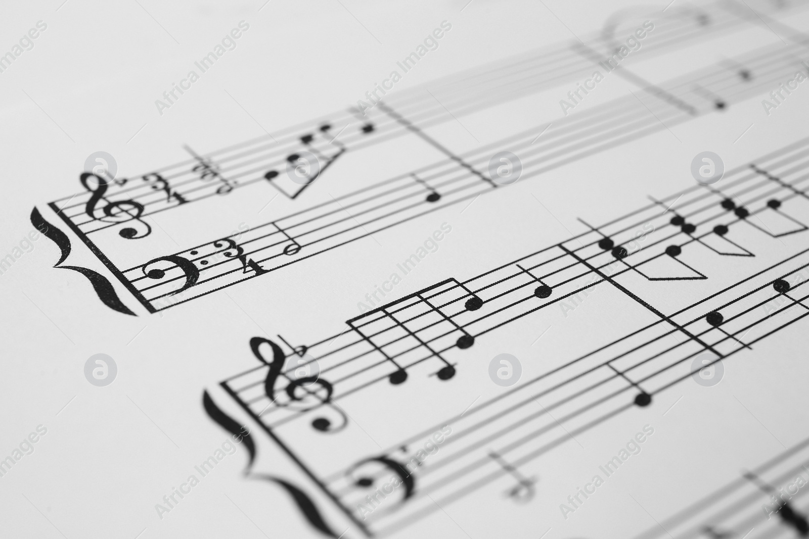 Photo of Sheet of paper with music notes as background, closeup view