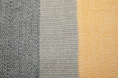 Soft striped knitted plaid as background, top view