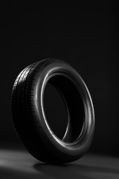 Photo of New car tire on black background