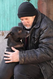 Photo of Poor homeless senior man with stray dog outdoors