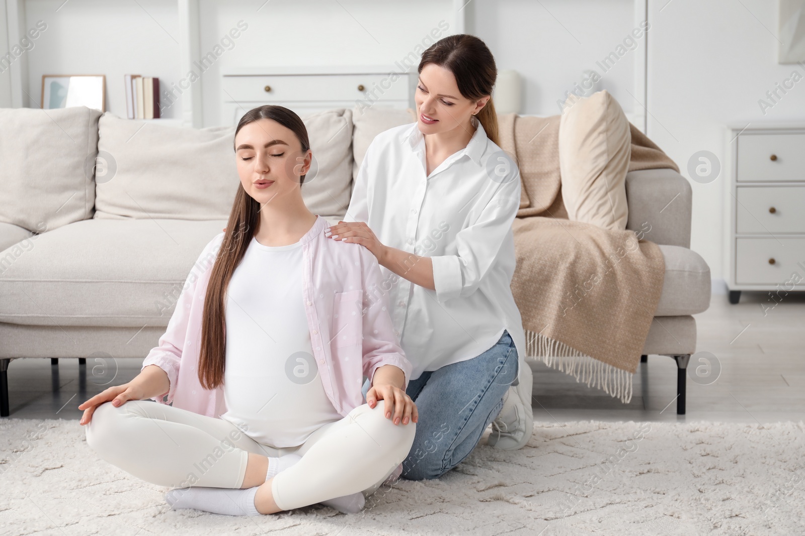 Photo of Doula taking care of pregnant woman at home. Preparation for child birth