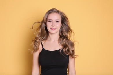 Photo of Portrait of young woman with long beautiful hair on color background