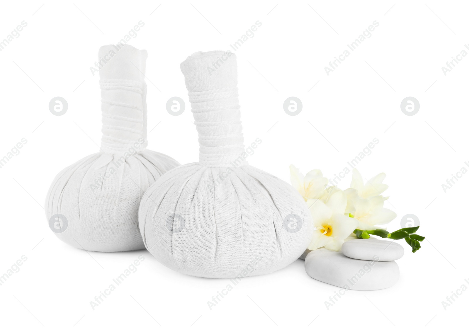 Photo of Herbal massage bags, flowers and spa stones on white background