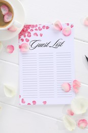 Photo of Guest list, coffee and petals on white wooden table, flat lay. Space for text
