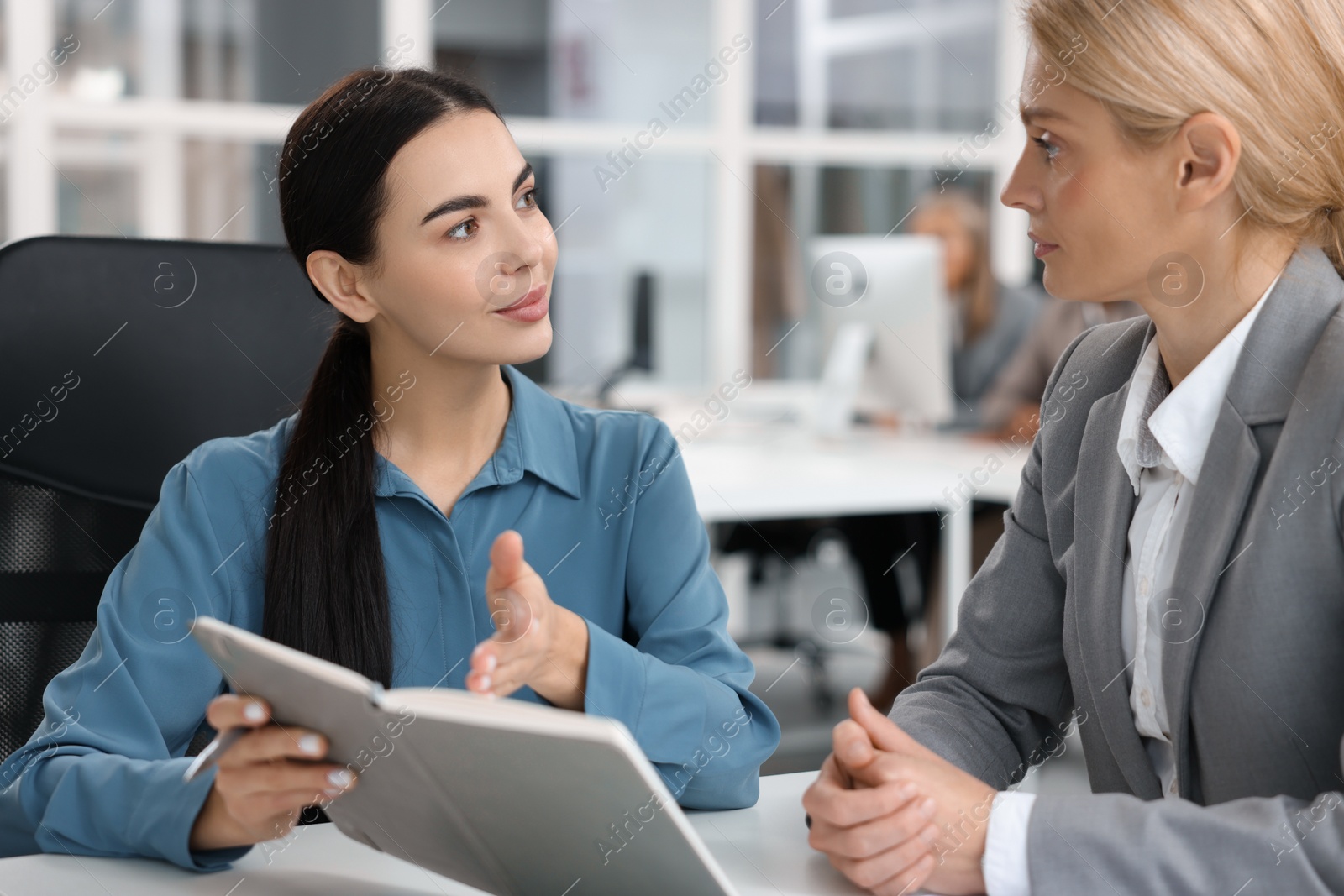 Photo of Lawyers with notebook working together at table in office, selective focus