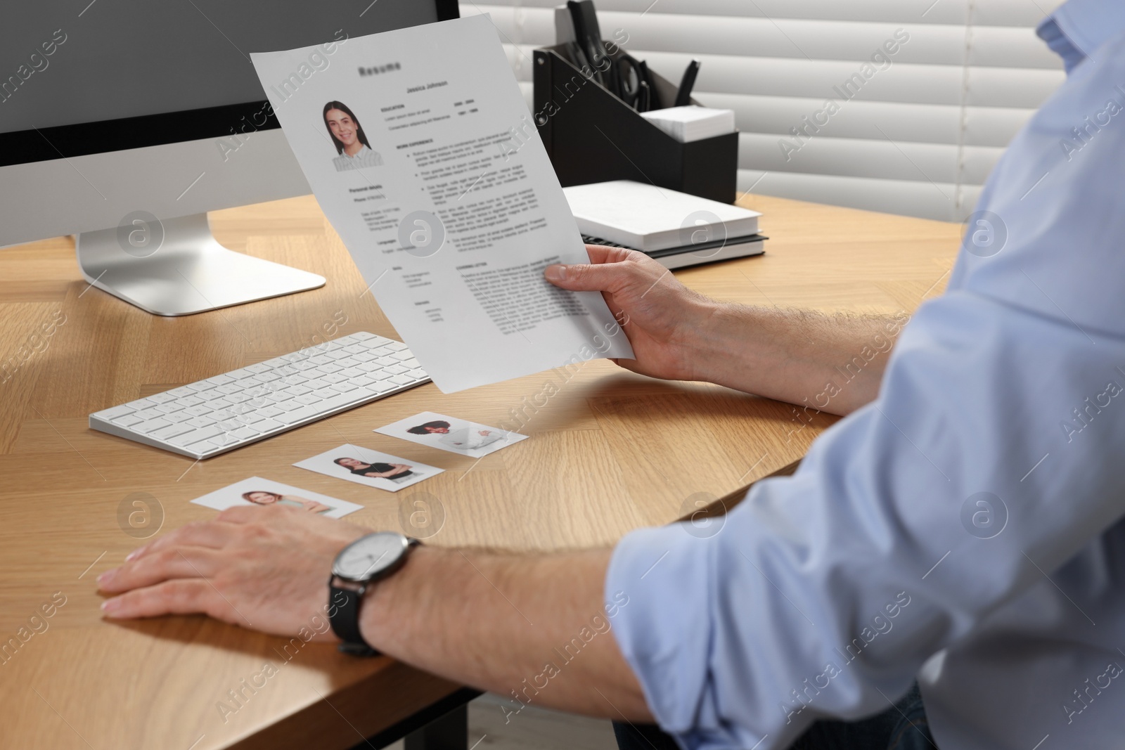 Photo of Human resources manager reading applicant's resume in office, closeup