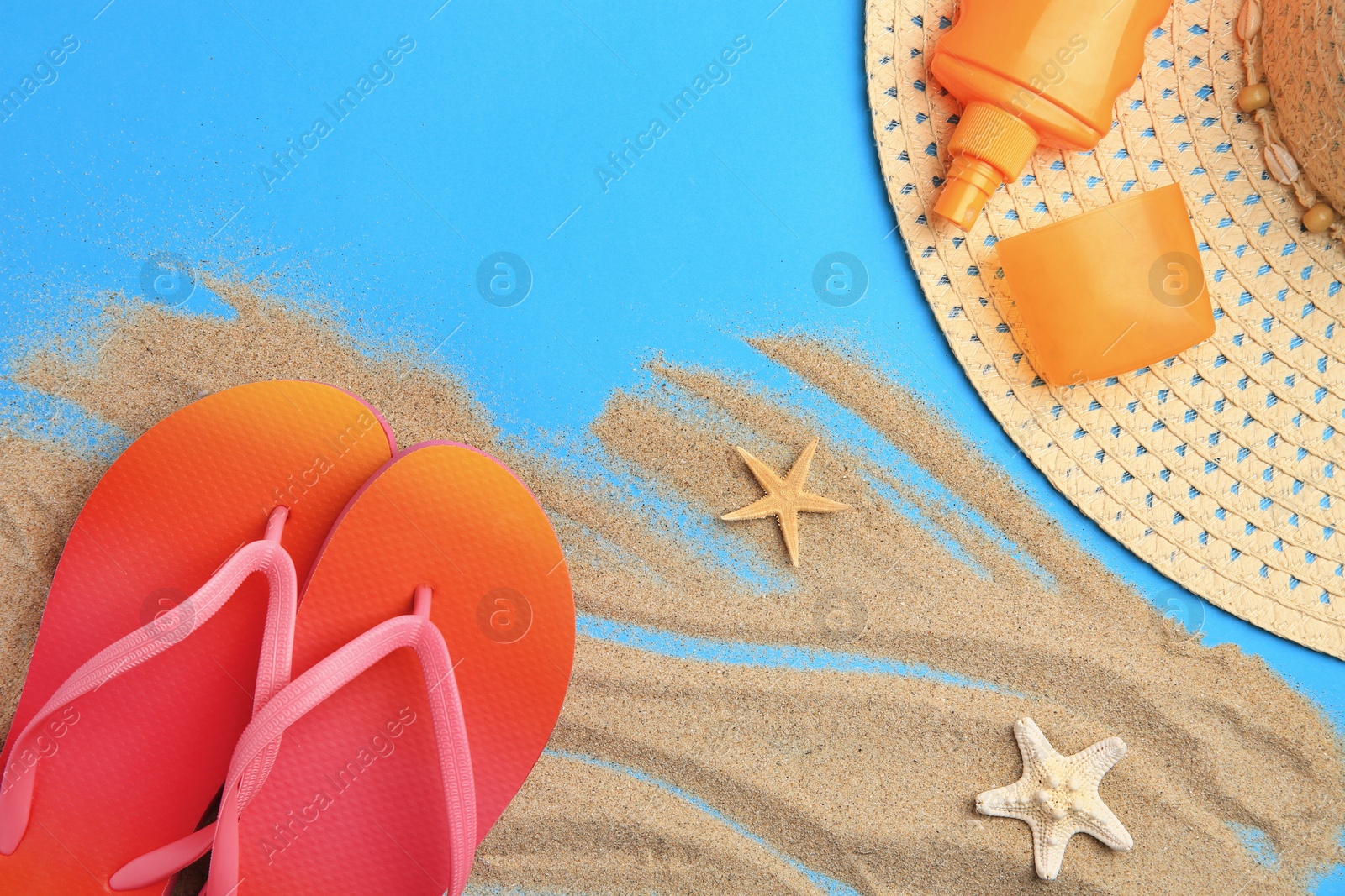 Photo of Flat lay composition with beach accessories on light blue background