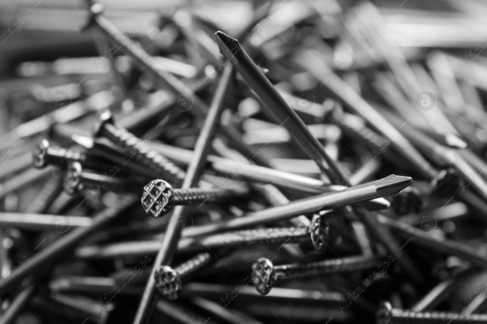 Photo of Pile of metal nails as background, closeup