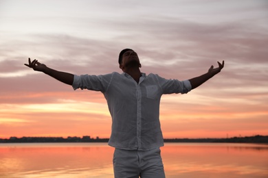 Man near river at sunset. Nature healing power