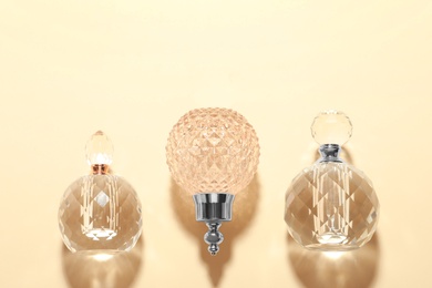 Photo of Different elegant perfume bottles on beige background, flat lay. Space for text