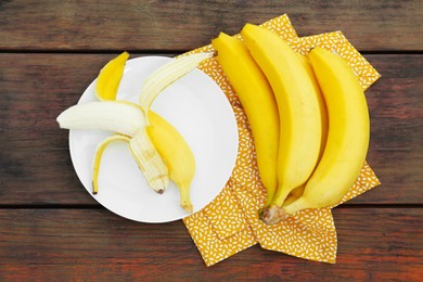 Many delicious ripe bananas on wooden table, flat lay