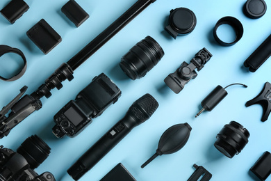 Flat lay composition with video production equipment for camera on light blue background