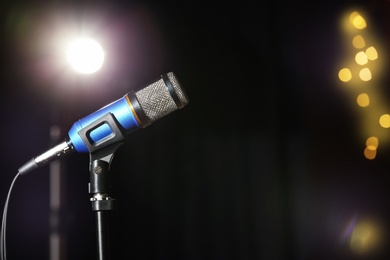 Photo of Stand with microphone on stage, space for text. Blurred lights