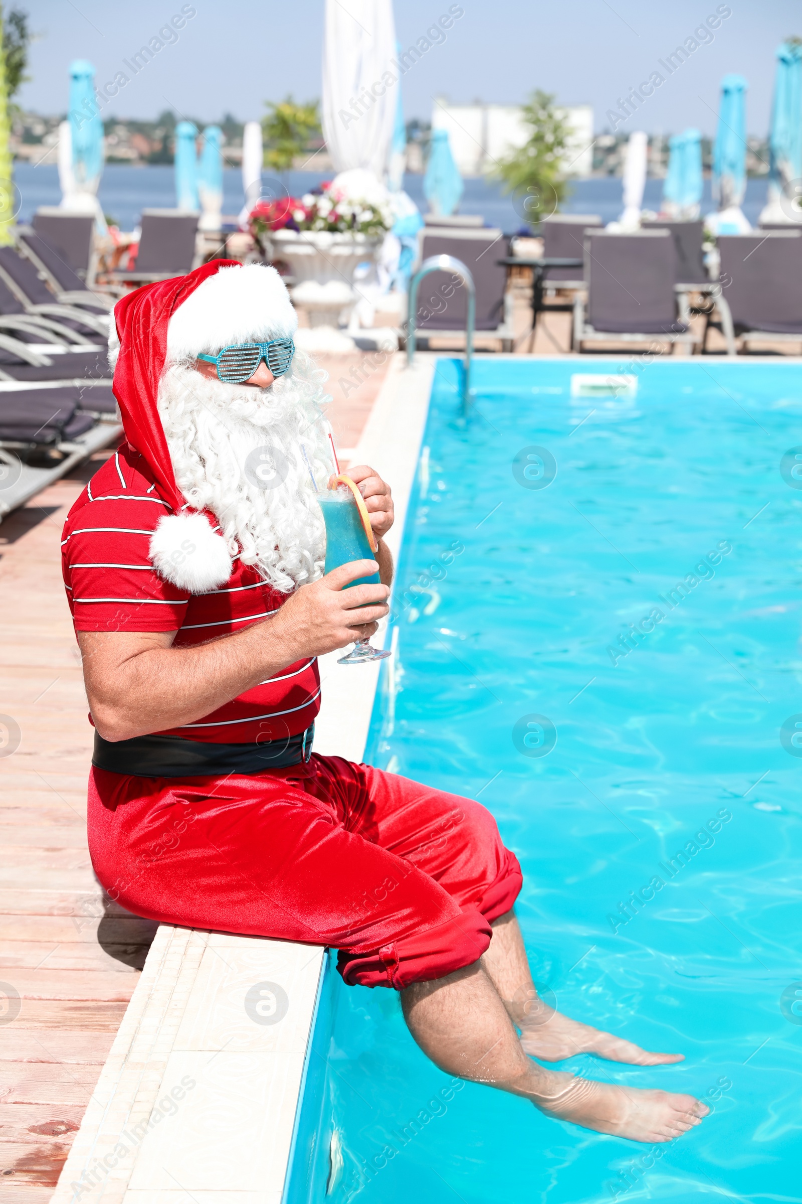 Photo of Authentic Santa Claus with cocktail near pool at resort