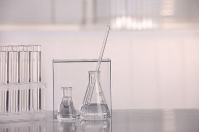 Photo of Laboratory analysis. Different glassware with liquid on white table indoors, space for text