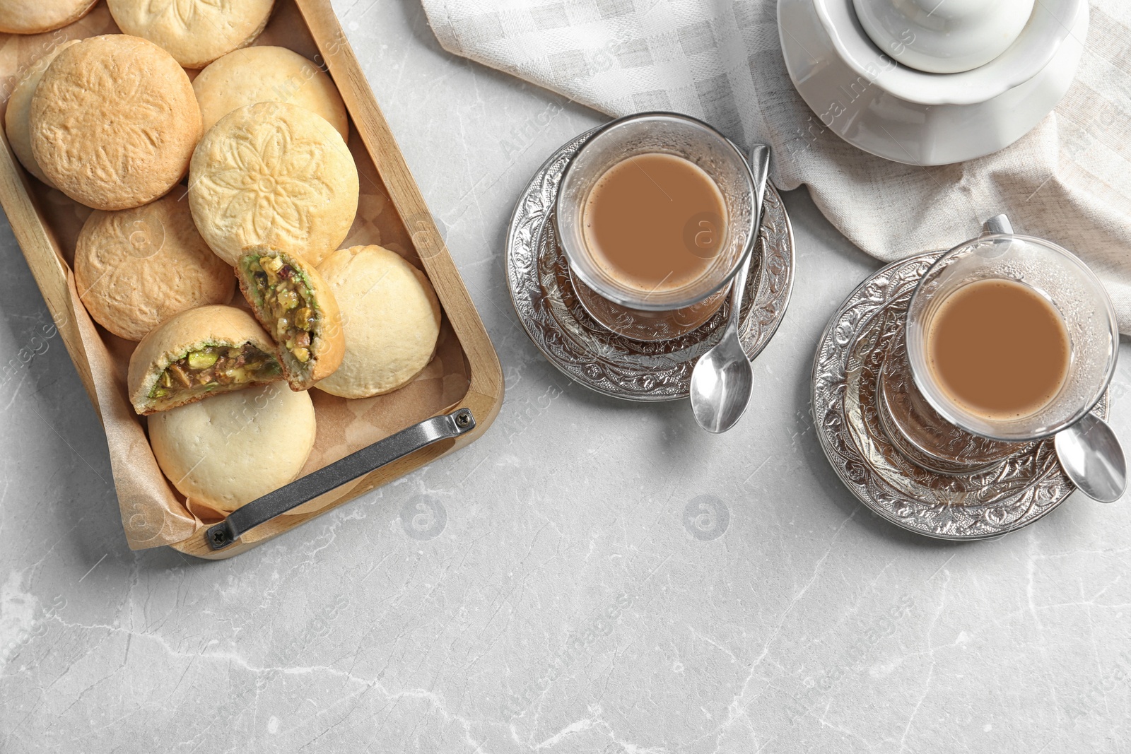 Photo of Flat lay composition with tray of cookies for Islamic holidays and cups on table. Eid Mubarak