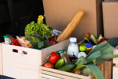Wooden crates with fresh products in car trunk. Food delivery service