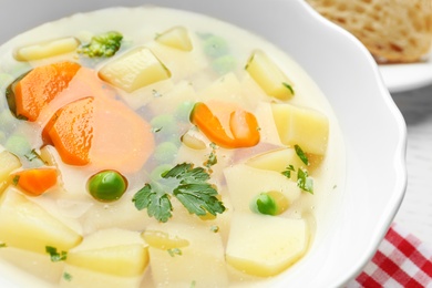 Bowl of fresh homemade vegetable soup on table, closeup