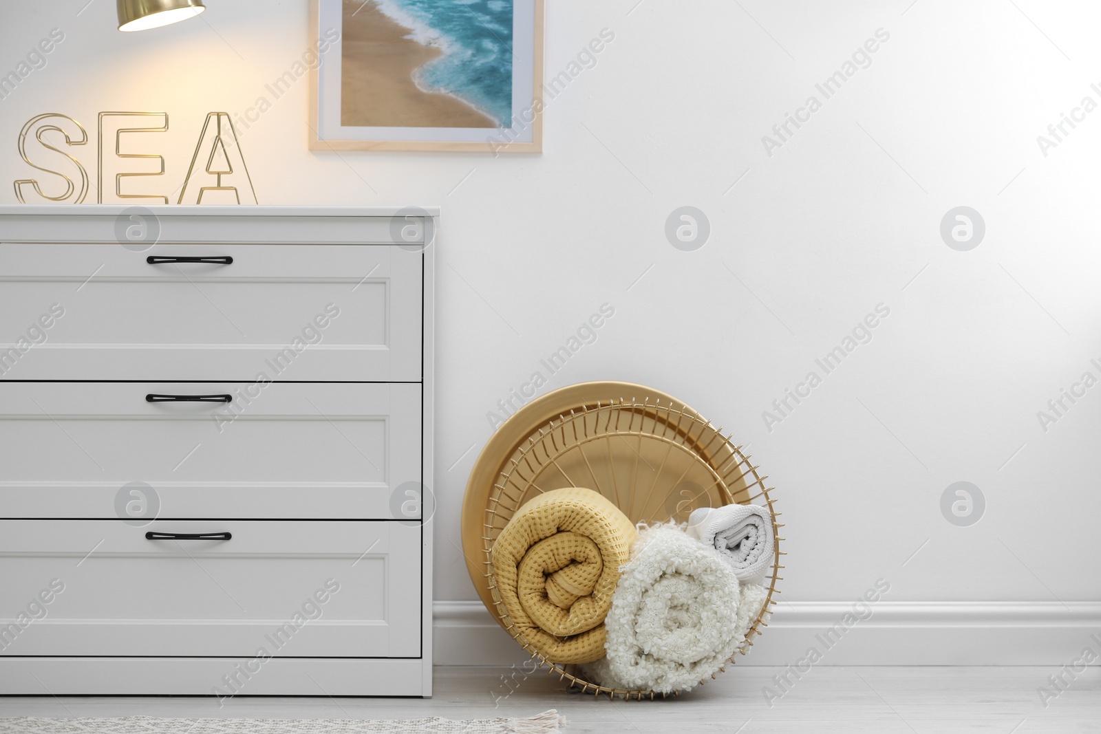 Photo of Basket with soft plaid near commode in room