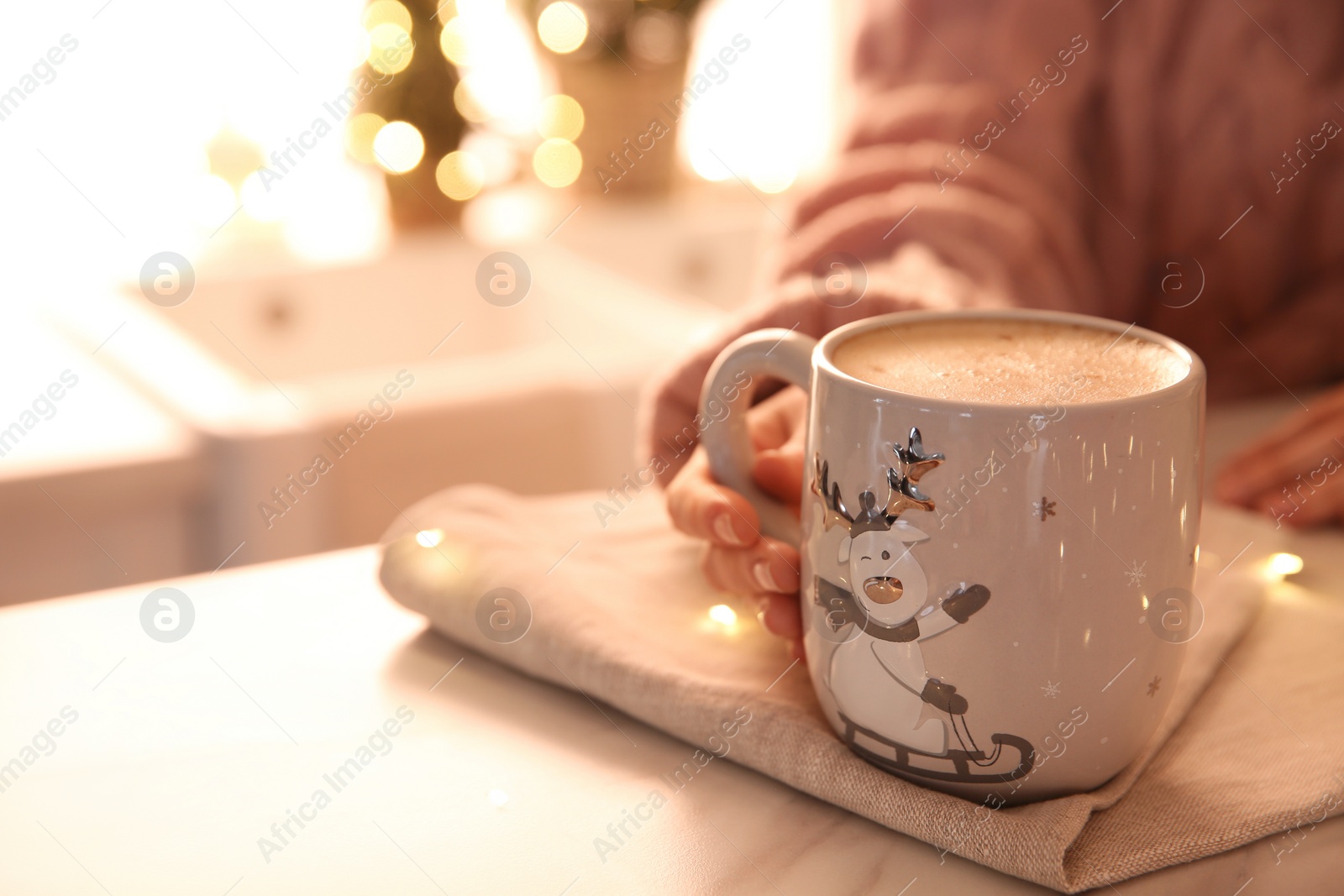 Photo of Woman holding cup with hot drink indoors, closeup