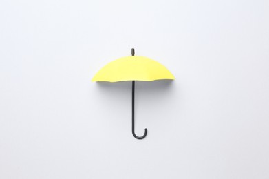 Yellow mini umbrella on white background, top view