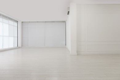 Empty room with white walls and laminated flooring