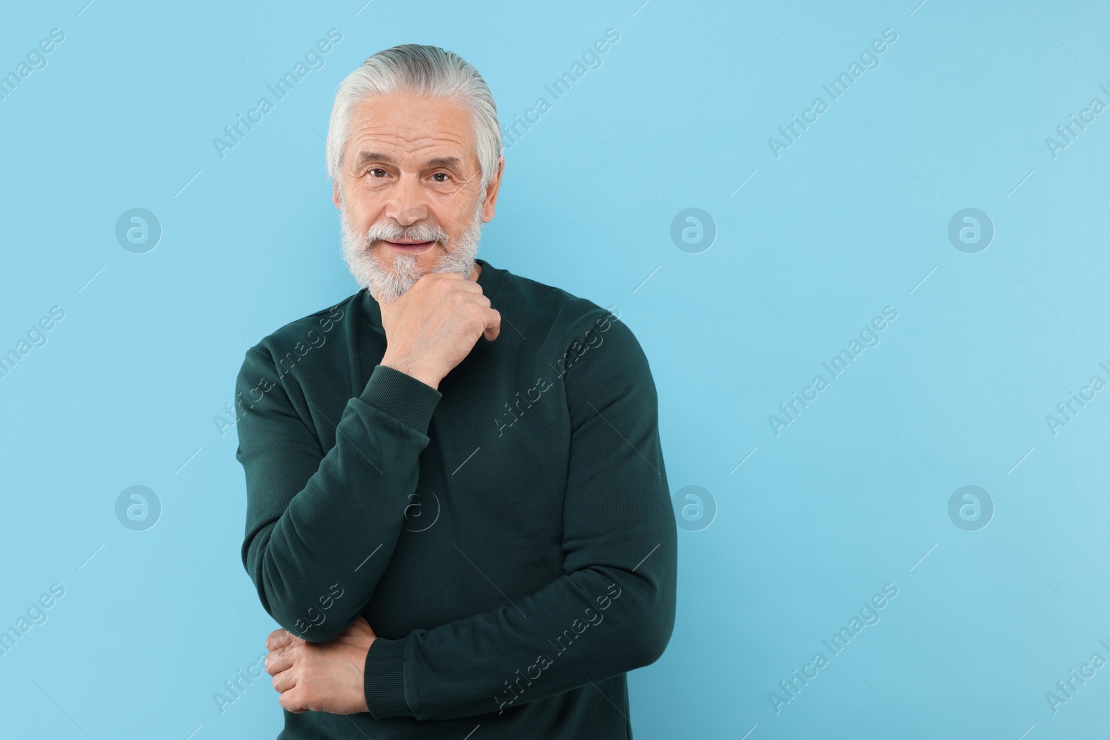 Photo of Portrait of handsome senior man on light blue background. Space for text