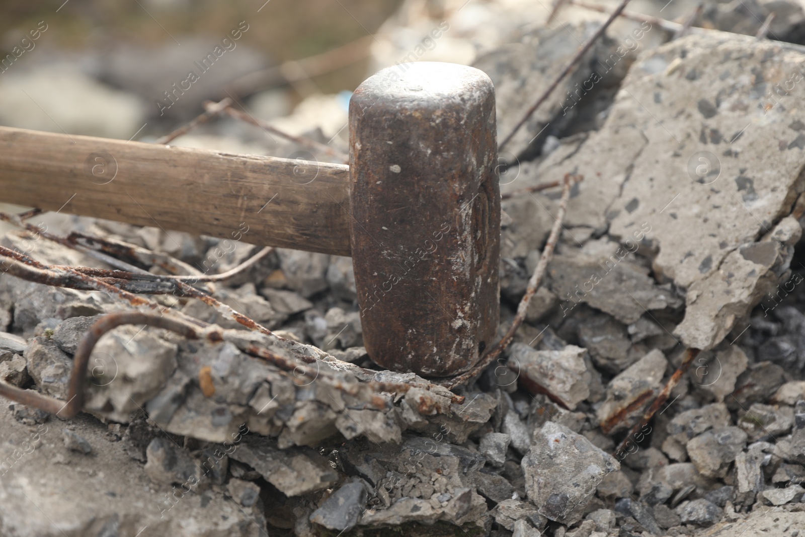 Photo of Sledgehammer on pile of broken stones outdoors, closeup