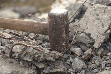 Photo of Sledgehammer on pile of broken stones outdoors, closeup