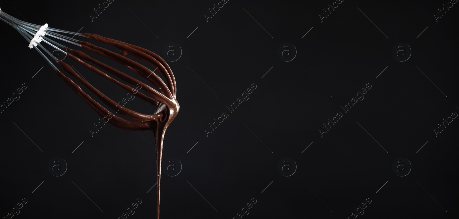 Image of Whisk with yummy chocolate cream on black background, closeup. Banner design with space for text