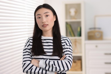 Portrait of beautiful businesswoman with crossed arms in office