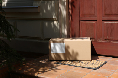 Delivered parcel on door mat near entrance