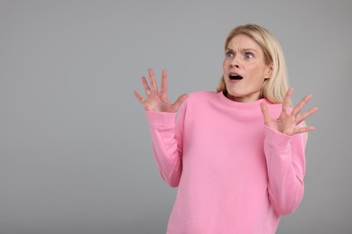 Photo of Portrait of surprised woman on grey background, space for text