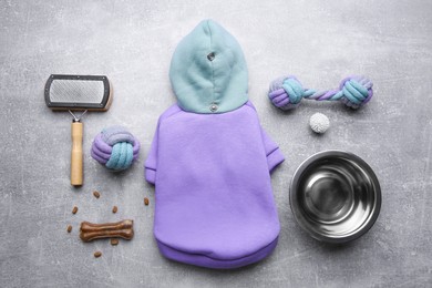 Photo of Flat lay composition with dog clothes, food and accessories on grey table