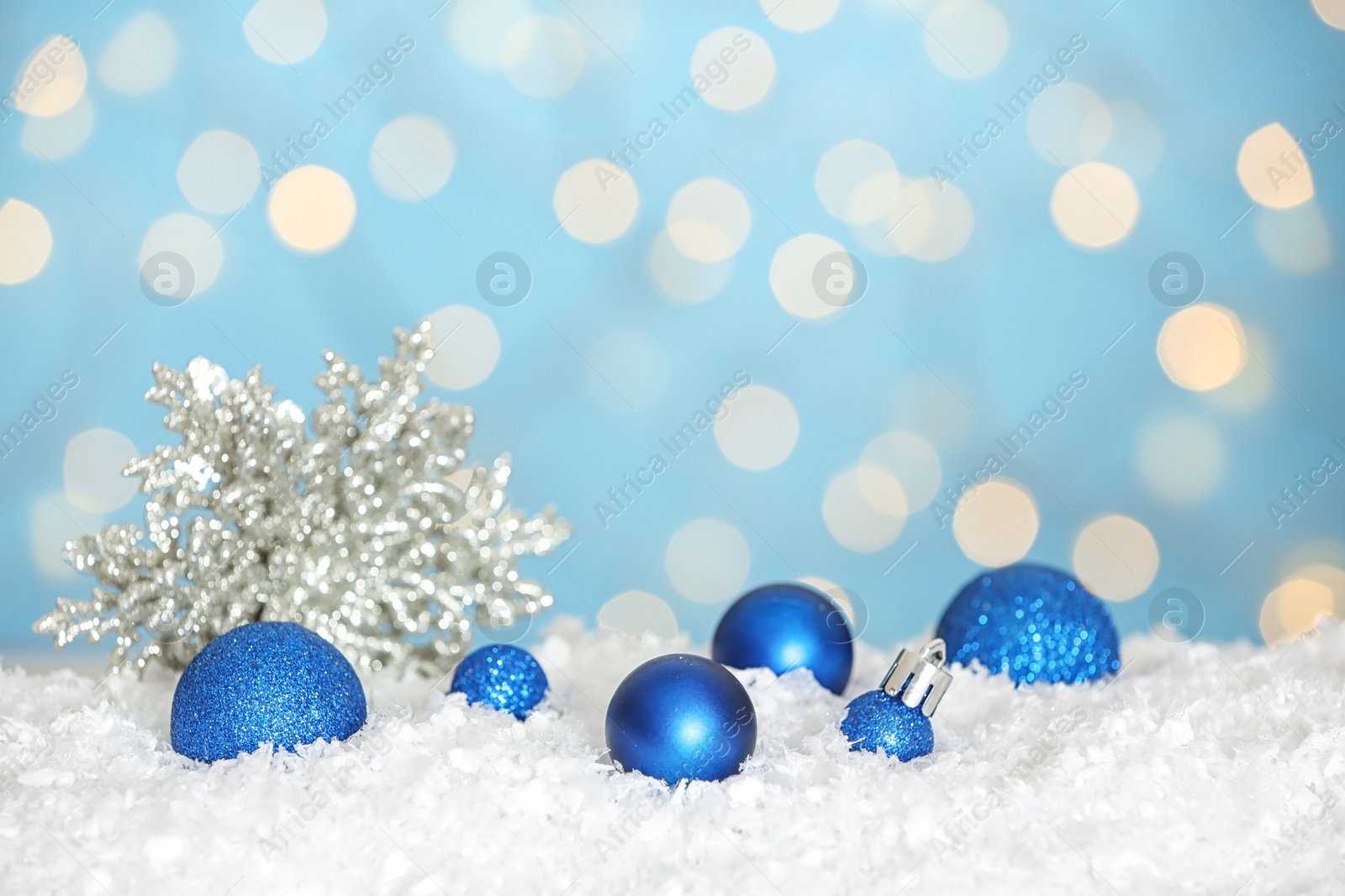 Photo of Christmas decoration on snow against blue background