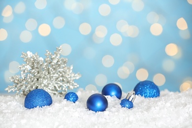 Photo of Christmas decoration on snow against blue background