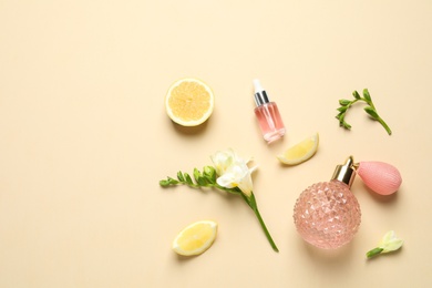 Photo of Flat lay composition with elegant perfume on beige background, space for text