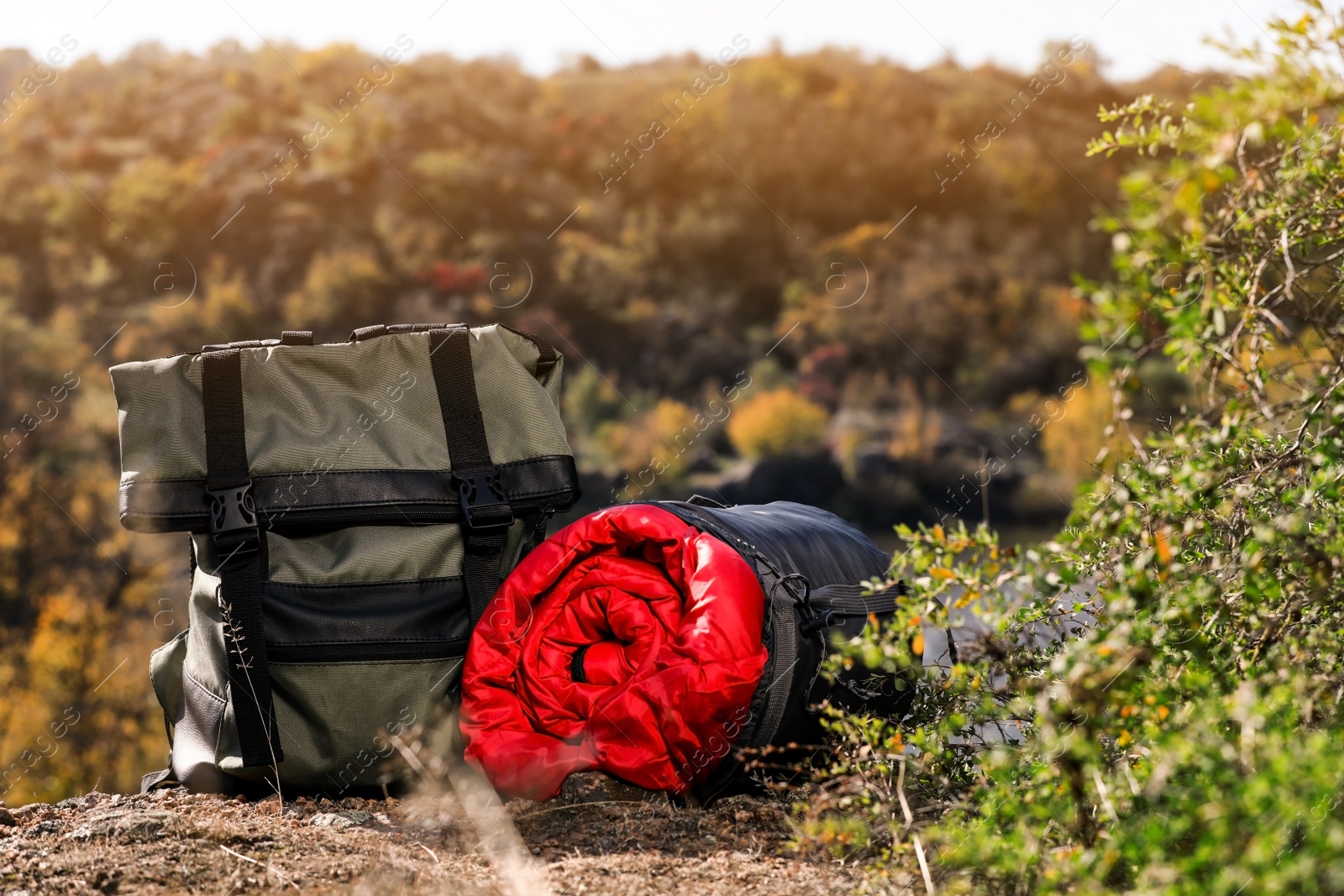 Photo of Backpack and sleeping bag on ground outdoors. Camping equipment