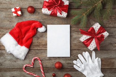 Flat lay composition with empty card and Christmas decoration on wooden background. Writing letter to Santa Claus