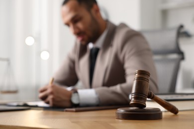 Photo of Lawyer working at table in office, focus on gavel